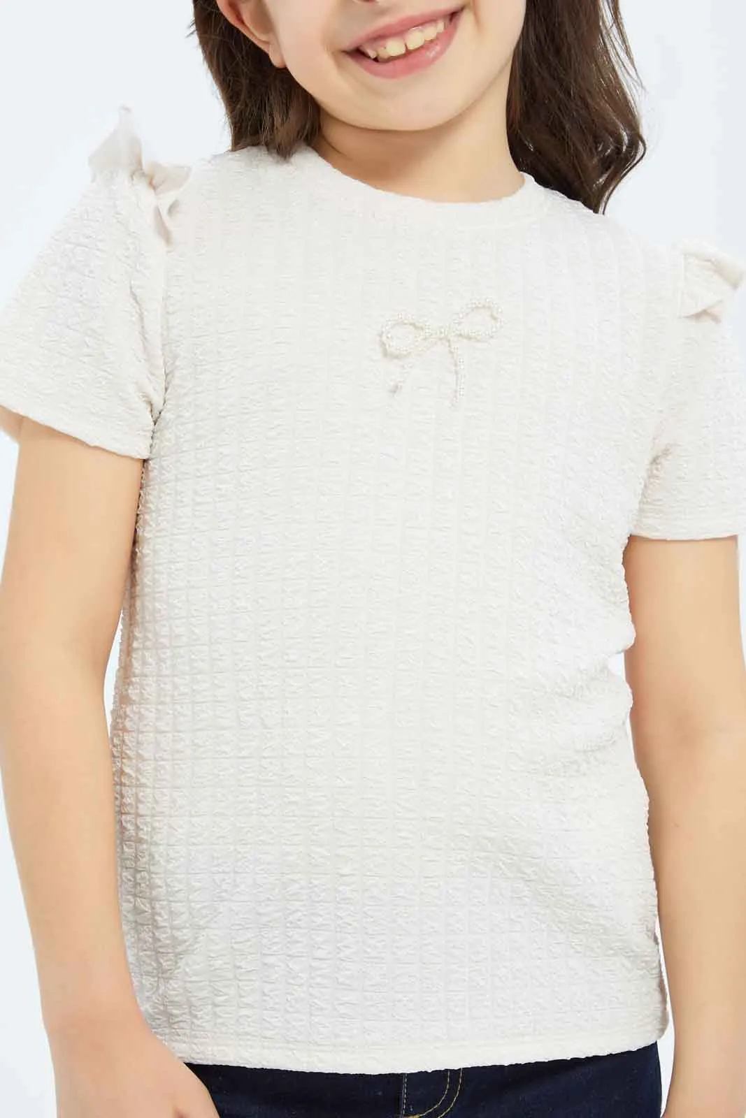 Girls Peach Textured Top With Attached Ribbon On Chest