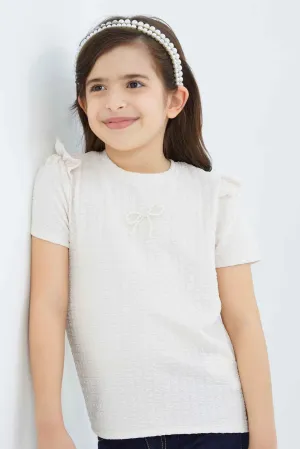 Girls Peach Textured Top With Attached Ribbon On Chest